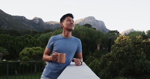 Man Enjoying Serene Mountain View Holding Mug