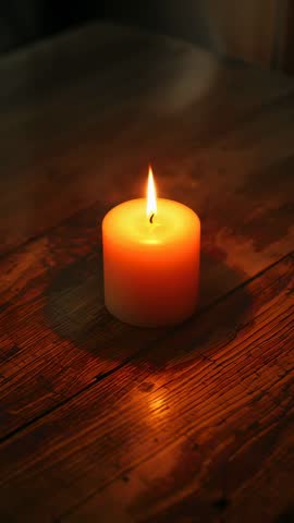 Vertical candlelight loop: Flickering wax candle on rustic wood table creating warm cozy glow