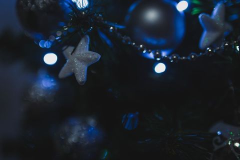 Glowing Stars and Ornaments on Christmas Tree at Night