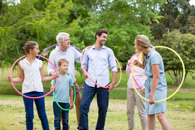 Multi-generation family holding hula hoop in park