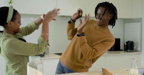 African american couple playfully baking in cozy modern kitchen laughing over flour