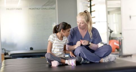 Physical Therapist Assisting Young Girl During Rehabilitation