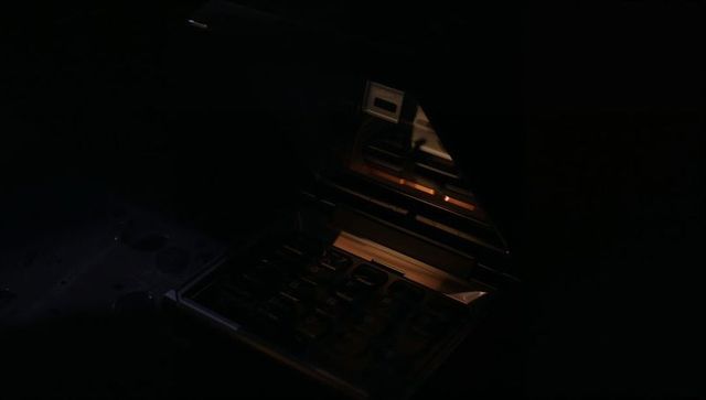 Moody low-light calculator glowing with amber highlights reflecting on hinged cover