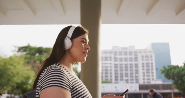 Woman Listening to Music on Headphones in Urban Park - Download Free Stock Images Pikwizard.com