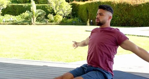 Man Practicing Outdoor Meditation and Stretching on Wooden Deck