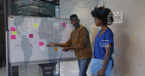 Professionals collaborating at whiteboard brainstorming global strategy with sticky notes