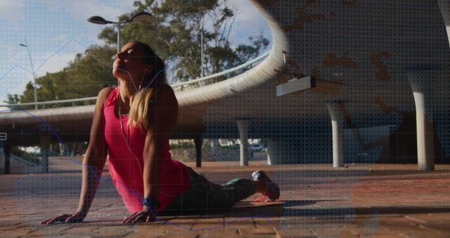 Young woman in sportswear practicing yoga under a modern bridge. She is stretching and enjoying the moment in the sunlight. Perfect for promoting outdoor fitness, healthy living, yoga practice, urban exercising environments, and modern lifestyle marketing.