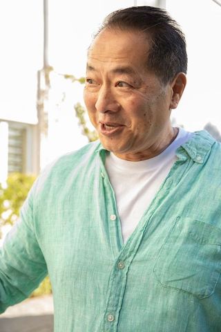 Mature asian man in casual linen shirt enjoying sunny day