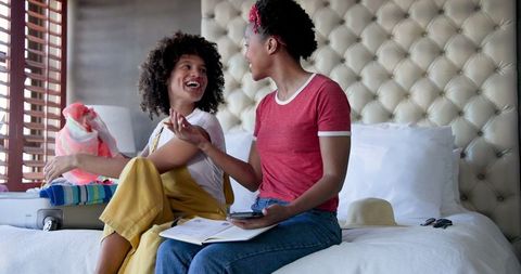 Diverse Female Couple Joyfully Packing Suitcase for Vacation