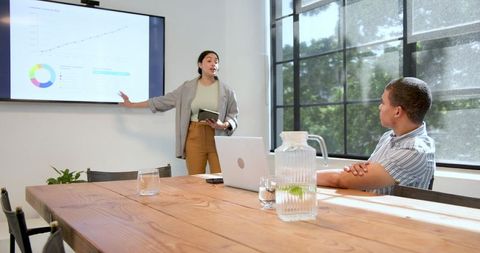 Businesswoman Presenting to Colleague in Conference Room