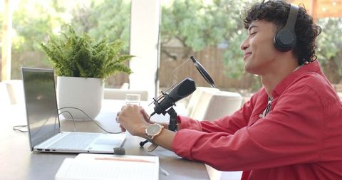 Young asian man engaging in podcast recording at home workspace