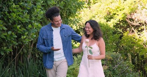 Couple Enjoying a Joyful Walk in Lush Garden