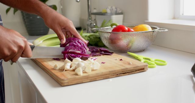 Biracial male cookery vlogger preparing food in sunny kitchen. Internet, communication, social media, cooking, food and lifestyle concept, unaltered.