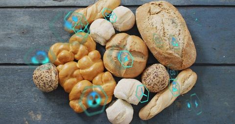 Assorted artisan breads flatlay with teal holographic icons on rustic blue wooden planks