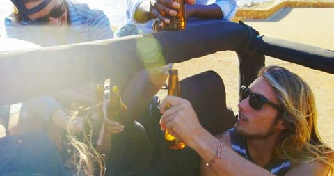 Friends Toasting in Convertible on Coastal Drive under Sunshine