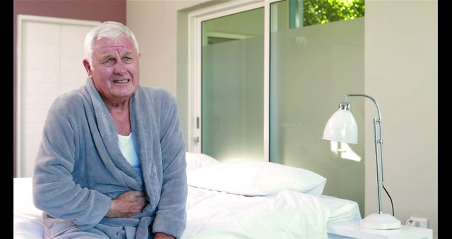 Senior Man in Pain Sitting on Bed in Modern Bedroom - Download Free Stock Images Pikwizard.com