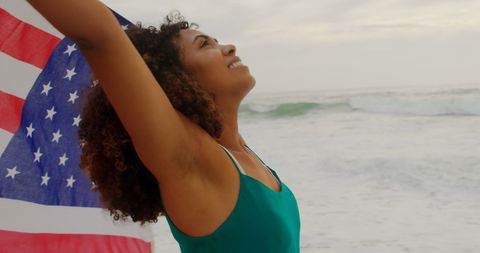Joyful African American Woman Celebrating with Flag at Beach