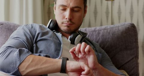 Relaxed Man Checking Smartwatch Notifications at Home