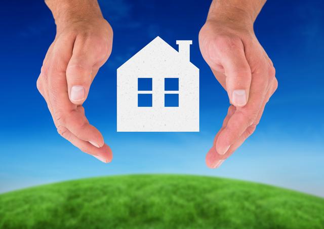 Hands forming a protective gesture around a house symbol, set against a backdrop of green grass and a clear blue sky. This image can be used for real estate advertisements, home insurance promotions, property management services, or environmental sustainability campaigns. It conveys themes of safety, security, and care for the home and environment.