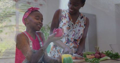 Mother and Daughter Cooking Together in Kitchen with Fresh Produce