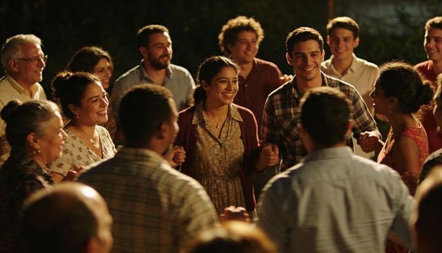 Multigenerational family holding hands in backyard celebrating warm evening gathering