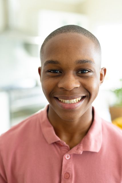 Portrait of african american male teenager smiling in living room. Spending quality time alone at home concept.