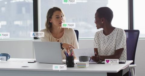 Diverse businesswomen engaged in office meeting discussing documents