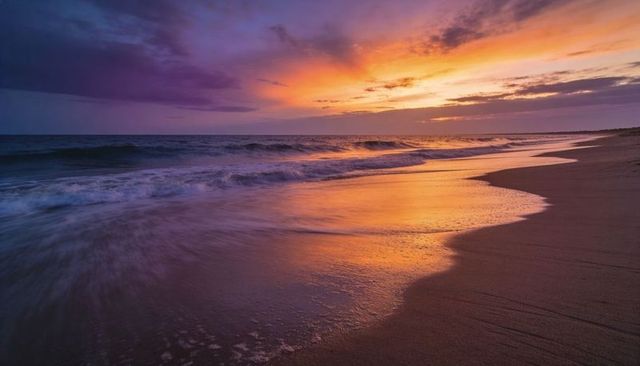 Sunset waves curving along golden shoreline reflecting orange clouds on wet sand