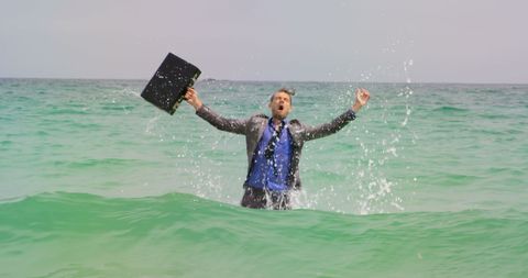 Joyful Businessman Celebrating in Ocean Water