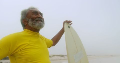 Joyful Senior Enjoying Surfing on Beach