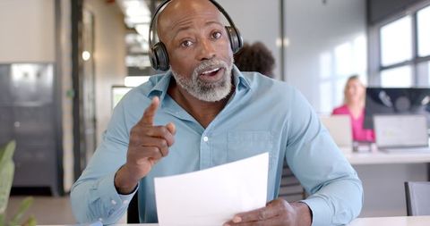 Focused african american businessman analyzing document in modern office setting