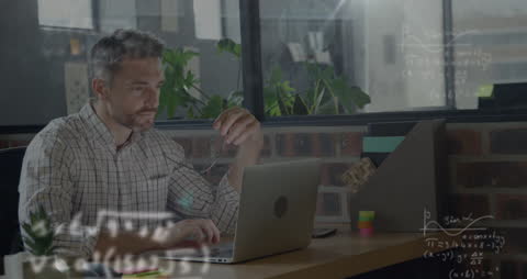 Businessman Analyzing Data on Laptop with Mathematical Equations