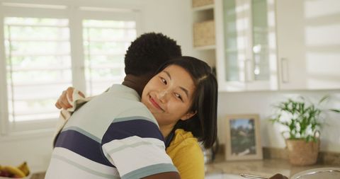 Happy Multiracial Couple Sharing Embrace in Home Kitchen - Download Free Stock Images Pikwizard.com