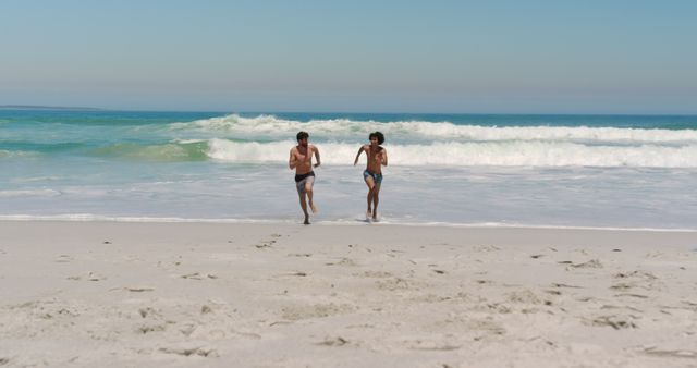 Young Friends Running from Ocean Waves on Sunny Beach Day - Download Free Stock Images Pikwizard.com