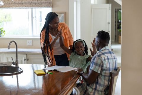 African american family celebrating homework success at kitchen island