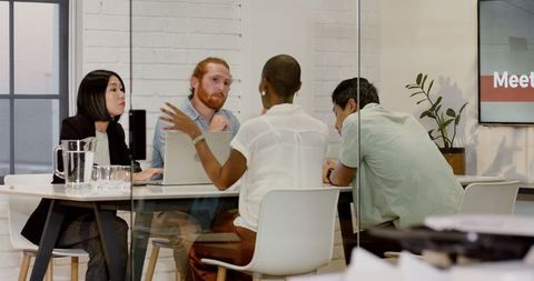 Diverse Team Strategizing in Modern Office Meeting Room