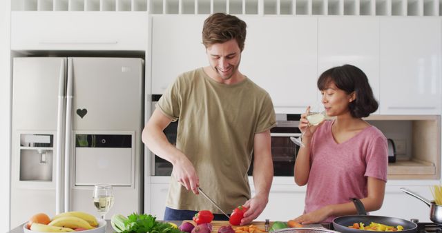 Image of happy diverse couple preparing meal together. Love, relationship and spending quality time together concept.