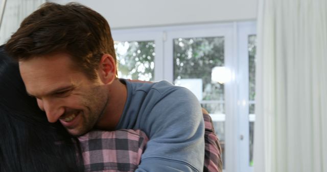 Happy Man Hugging Woman Indoors with Natural Light - Download Free Stock Images Pikwizard.com