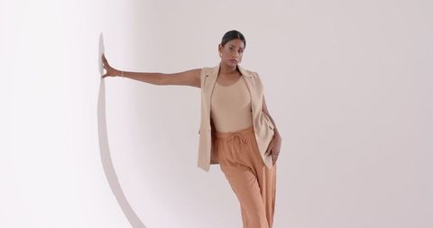 Elegant Woman in Neutral Tones Posing in Minimalist Studio
