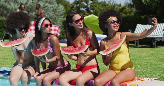 Group of diverse girls holding watermelon taking a selfie together on smartphone while sitting by the pool. youth friendship and pool party concept