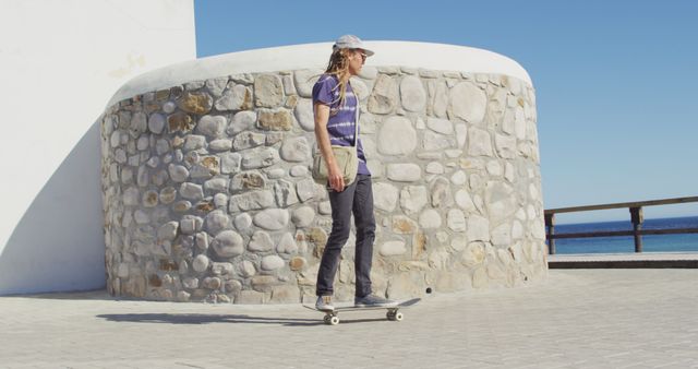 Man Skateboarding Next to Stone Wall Near Beach - Download Free Stock Images Pikwizard.com