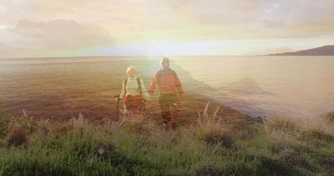 Couple Hiking on Coastal Bluff at Sunset Under a Warm Glow