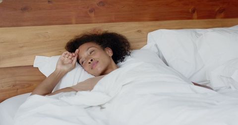 African american woman relaxing in comfortable bedroom