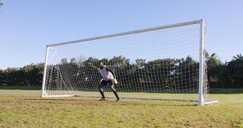 Goalkeeper Focused on Blocking Goal Outdoors in Bright Weather