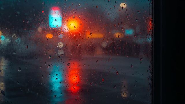 Rainy night window with neon light reflections