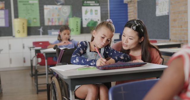 Teacher Assisting Young Girl in Wheelchair with Schoolwork in Classroom - Download Free Stock Images Pikwizard.com