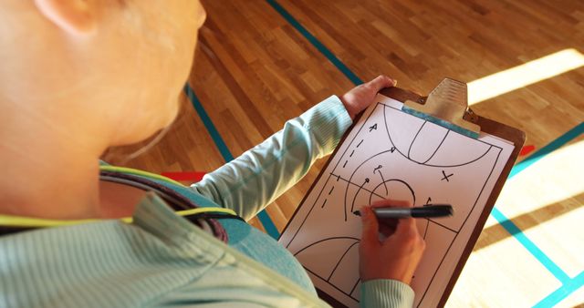 Basketball Coach Strategizing Game Plan on Clipboard - Download Free Stock Images Pikwizard.com