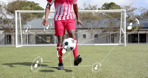 Soccer player dribbling on turf with digital network overlay and goal in background