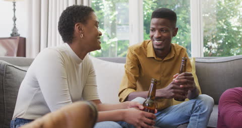 Friends Sharing Laughter While Enjoying Drinks at Home