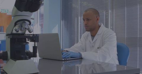 Scientist Analyzing Data on Laptop in Laboratory